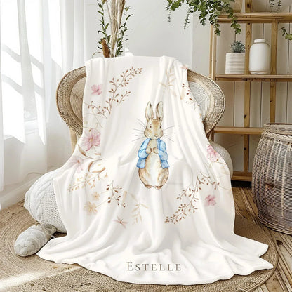 Custom child's name detail on Peter Rabbit storybook-themed nursery blanket.